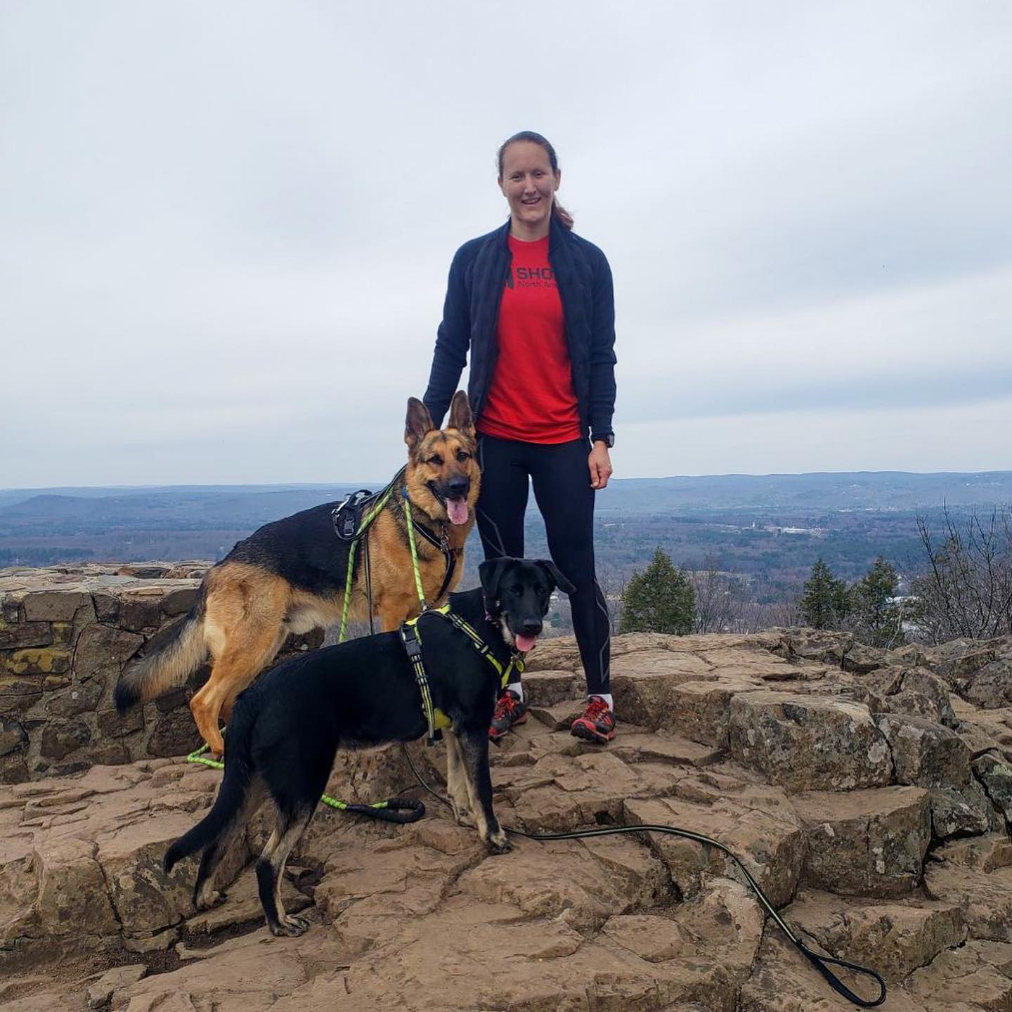 Lisa Wawrzynowski on mountain top with dogs in VJ Shoes XTRM and VJ Shoes tshirt
